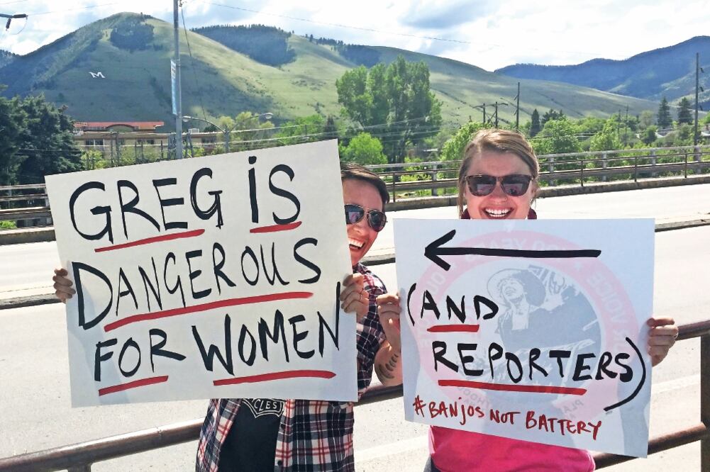 Dos mujeres sostienen letreros en Missoula, Montana, señalando que el candidato Gianforte es “peligroso para las mujeres... y reporteros”. (IVAN COURONNE. AFP)