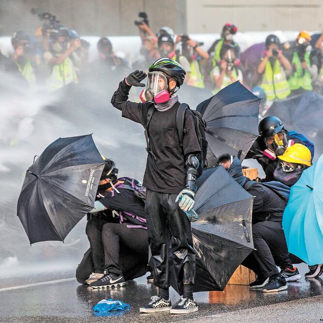 Manifestantes se enfrentaron a la policía, que disparó con cañones de agua afuera de la sede del gobierno en Hong Kong. Foto/ISAAC LAWRENCE. AFP