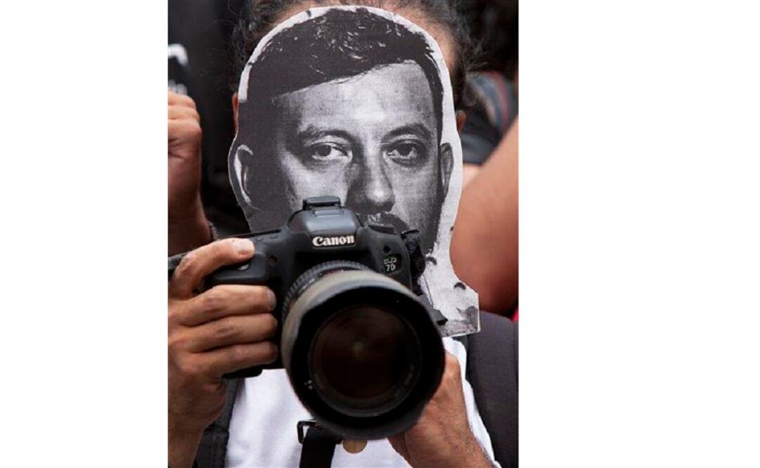 A photojournalist protests the murder of photojournalist Ruben Espinosa Becerril as he holds a printout of his photo, in Mexico City on Aug. 2, 2015. (Photo: AP)