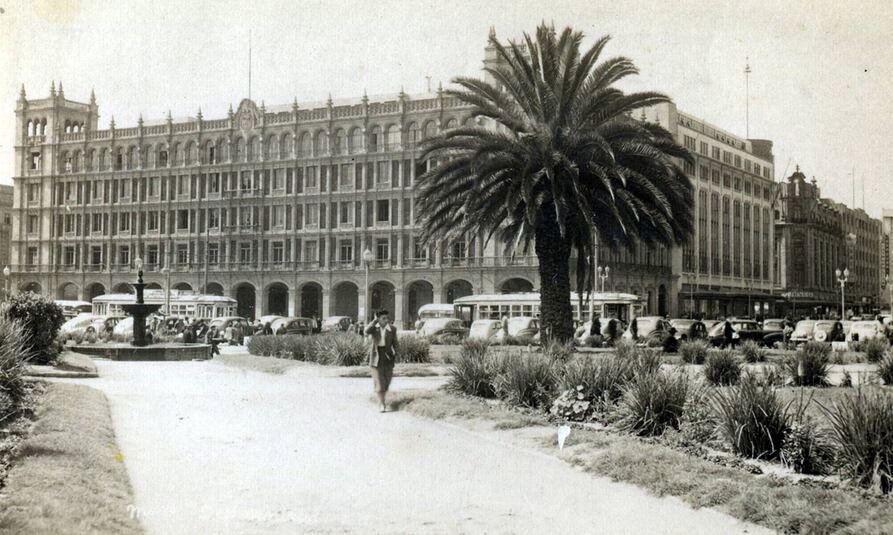 Postal de los años 40 de Avenida 20 de noviembre vista desde el Zócalo capitalino que entonces lucía con palmeras. Se observa a la izquierda el Palacio del Ayuntamiento y del lado derecho Liverpool. Foto: Colección Carlos Villasana.