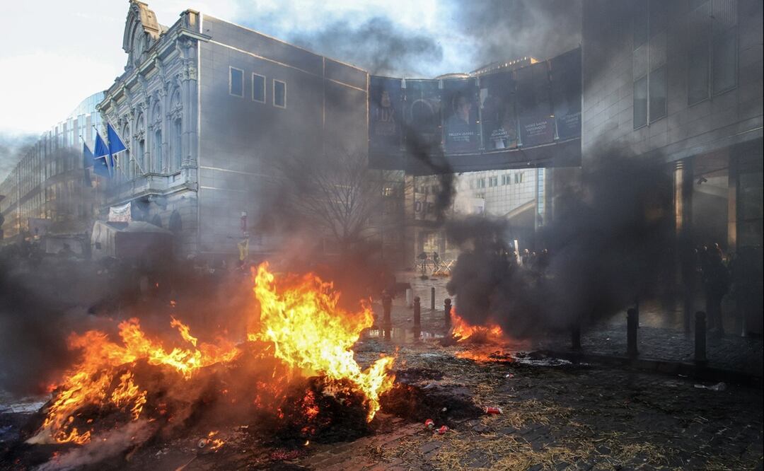 Agricultores concentrados ante la sede del Parlamento Europeo en Bruselas prendieron hogueras ante el cordón policial que les separaba del patio de acceso a la Eurocámara. Foto: EFE