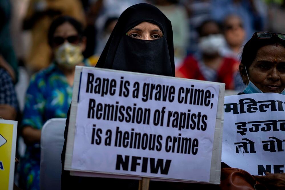 Una mujer musulmana sostiene una pancarta contra la remisión de sentencia por parte del gobierno a los convictos de una violación en grupo de una mujer musulmana en violencia comunitaria en 2002 en el estado occidental de Gujarat. Foto: AP