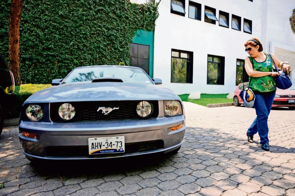 En Los Pinos, una visitante observó un Ford Mustang confiscado al crimen organizado, el cual será subastado el domingo. Foto: PEDRO PARDO. AFP