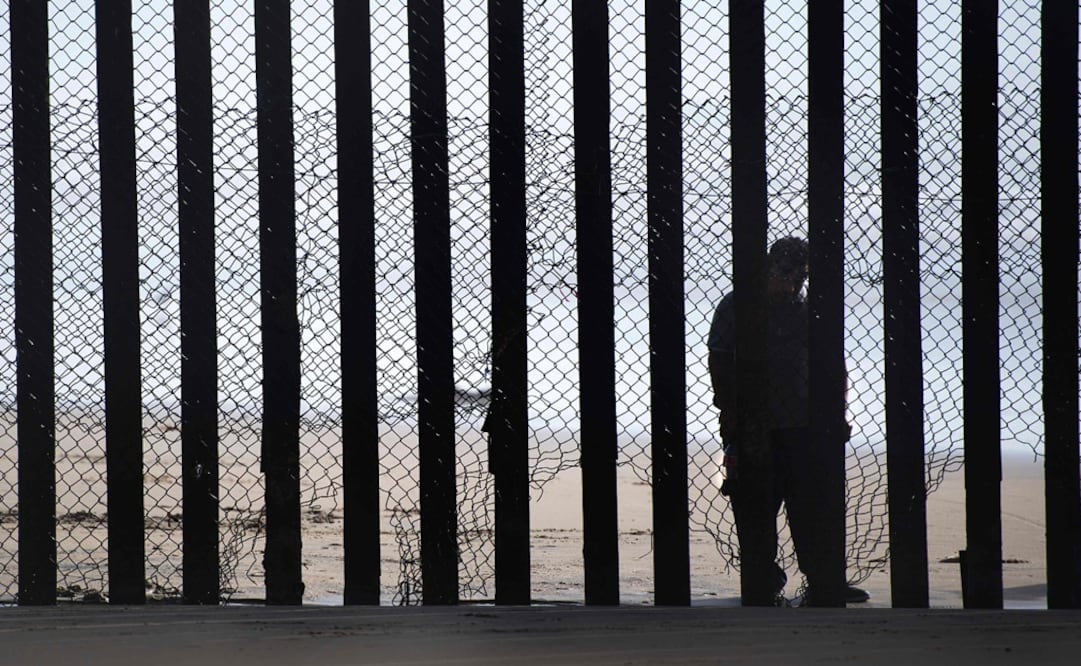 A man standing on the Mexico side of a border fence separating the beaches at Border Field State Park, in San Diego, CA - Photo: Jim Watson/AFP