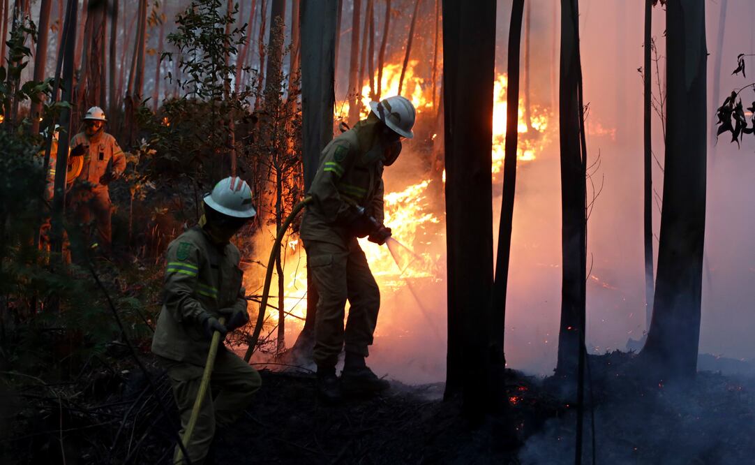 Bomberos de la Guardia Nacional Republicana portuguesa trabajan para impedir que un incendio alcance el pueblo de Avelar, en el centro de Portugal (AP Foto/Armando Franca)