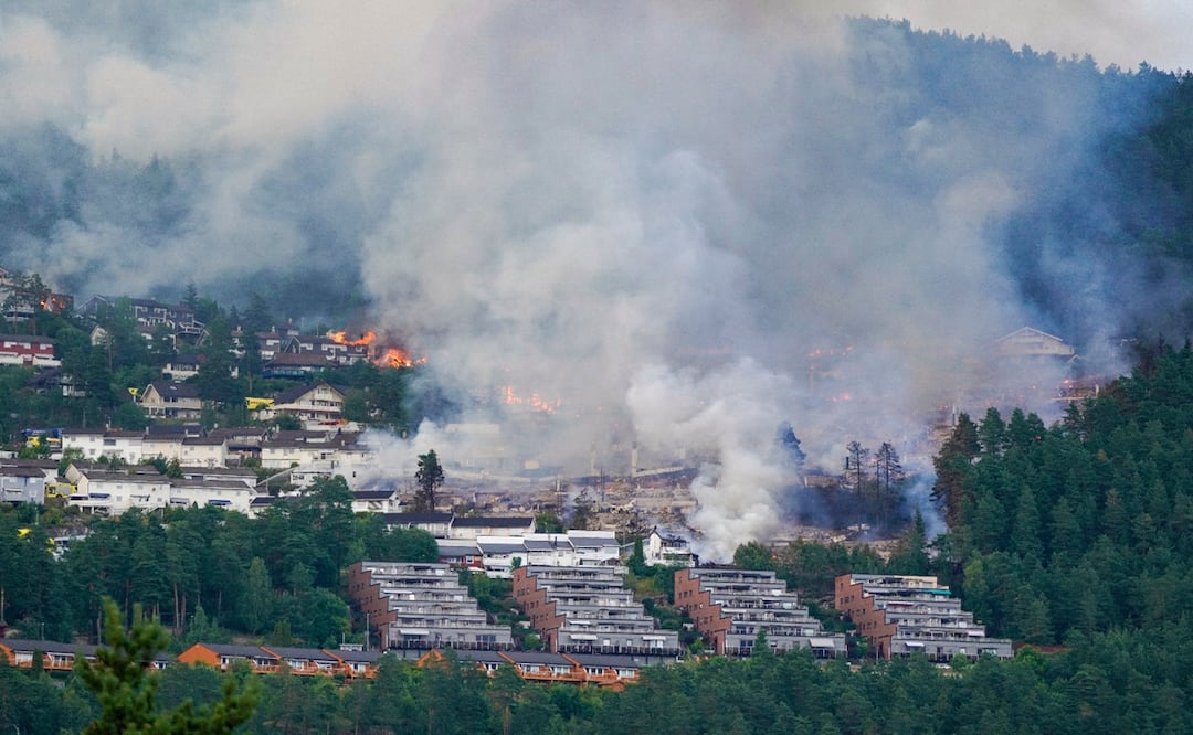 Una nube de humo sale de una zona residencial incendiada en la localidad de Krokstadelva, en Drammen, Noruega. Foto: AP