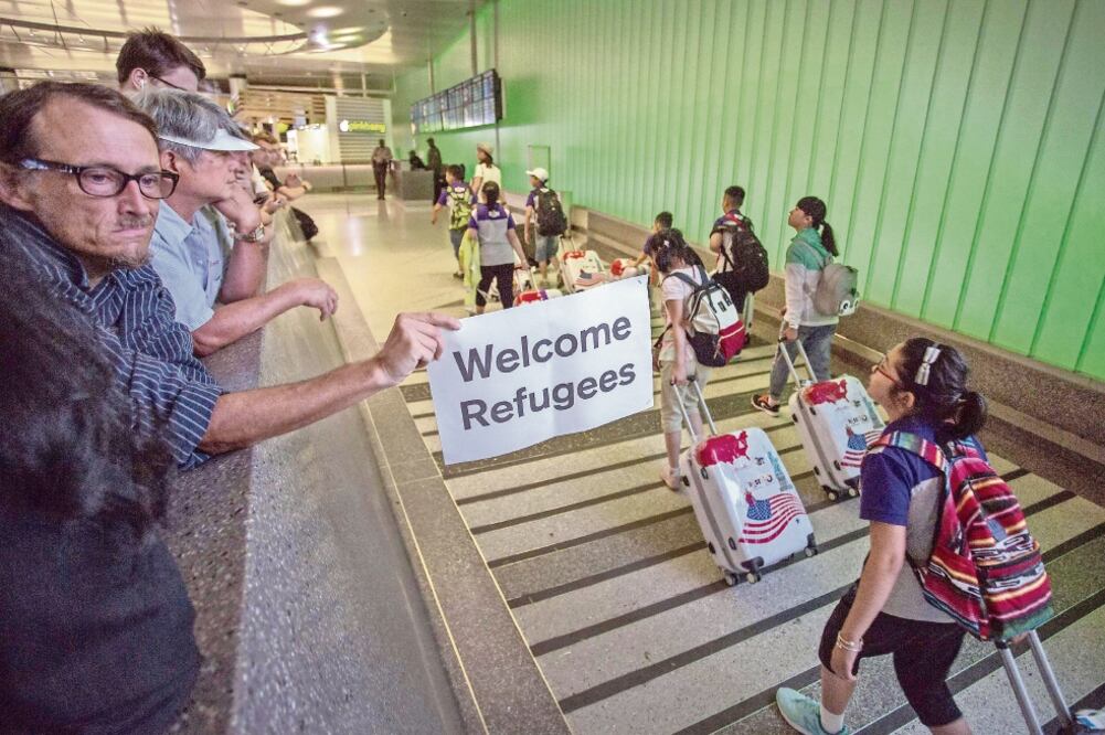 John Wider porta un letrero de bienvenida a los refugiados, ayer, en el aeropuerto de Los Ángeles, al entrar en vigor parcialmente el veto migratorio. Foto: Archivo/El Universal