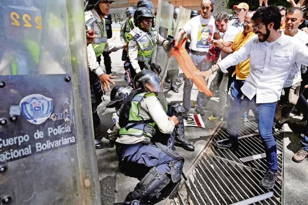 Opositores del gobierno de Nicolás Maduro se enfrentaron ayer a la Guardia Nacional durante una manifestación en la ciudad de Caracas. (MARCO BELLO. REUTERS)