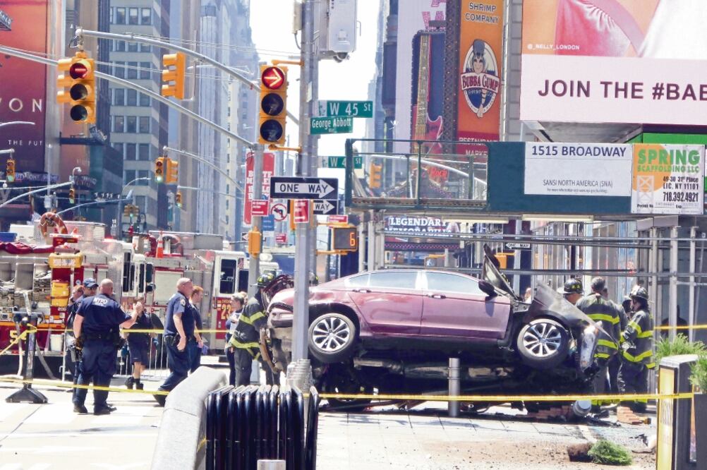 Bomberos trabajan en el auto queembestió a peatones en Times Square y posteriormente se fue a estrellar contra un poste. El conductor, de 26 años y residente de El Bronx, se encuentra detenido (MIKE SEGAR. REUTERS)