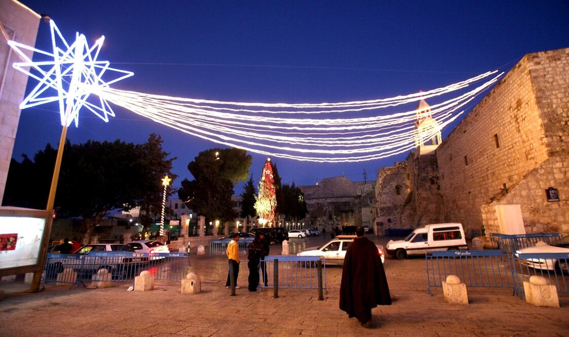 Un monje franciscano camina bajo la estrella que decora Manger Square, en la ciudad cisjordana de Belén.
Foto: EFE, archivo