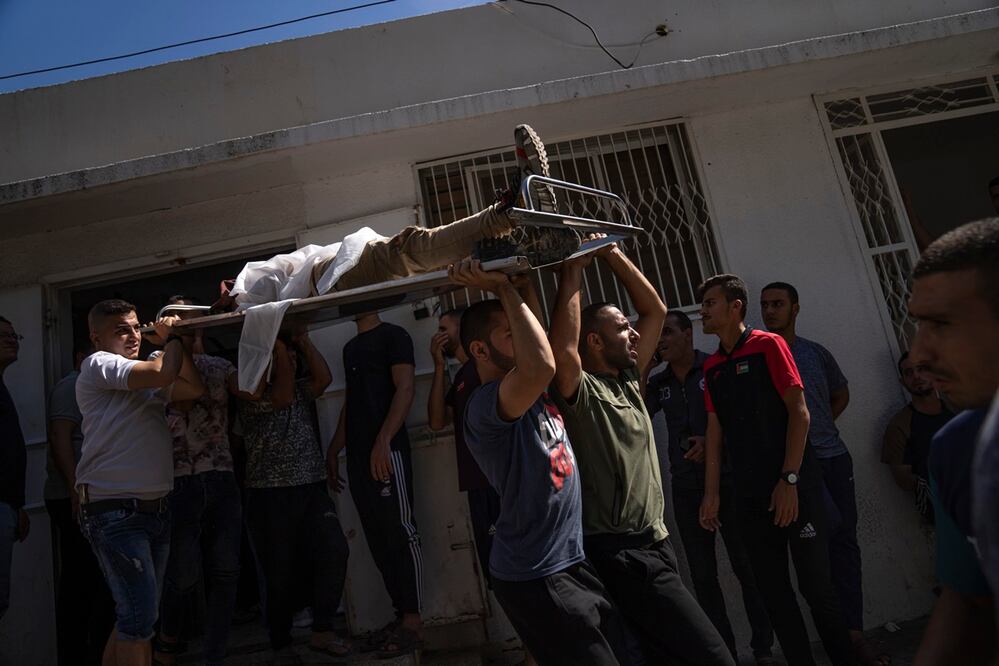 Palestinos cargan el cuerpo de un hombre muerto durante los combates con las fuerzas israelíes, en la ciudad de Gaza, el sábado 7 de octubre de 2023. Foto: AP