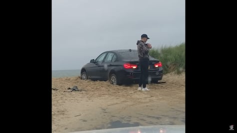 Hombre queda fuera de su auto mientras lo ve atascarse en la arena