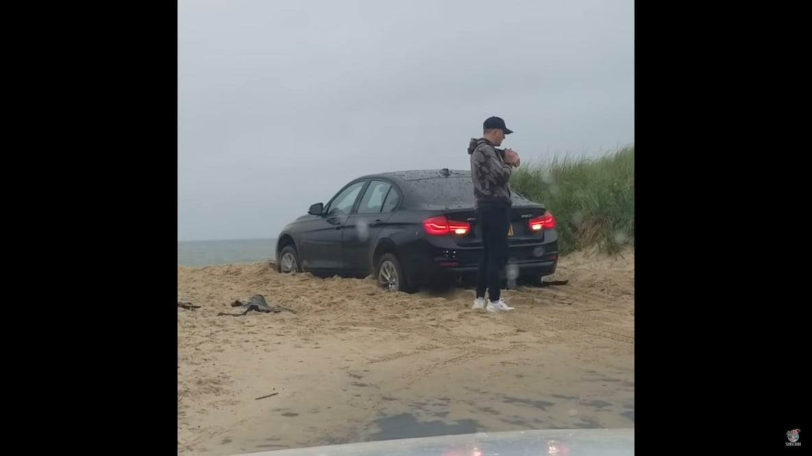 Hombre queda fuera de su auto mientras lo ve atascarse en la arena