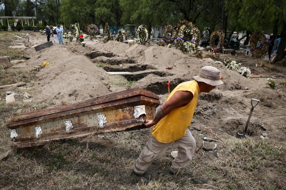 Trabajadores del panteón San Lorenzo Tezonco sepultan a víctimas de Covid. Al cementerio sólo se permite el acceso de dos familiares por servicio funerario. Foto: DIEGO SIMÓN. EL UNIVERSAL