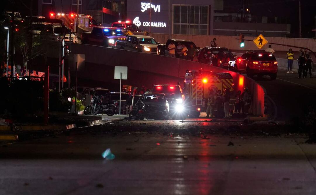 Policías, bomberos y agentes de seguridad inspeccionan los daños en el lugar de la explosión de un automóvil en una calle comercial de Guayaquil, Ecuador, el martes 14 de octubre de 2025. Foto: AP