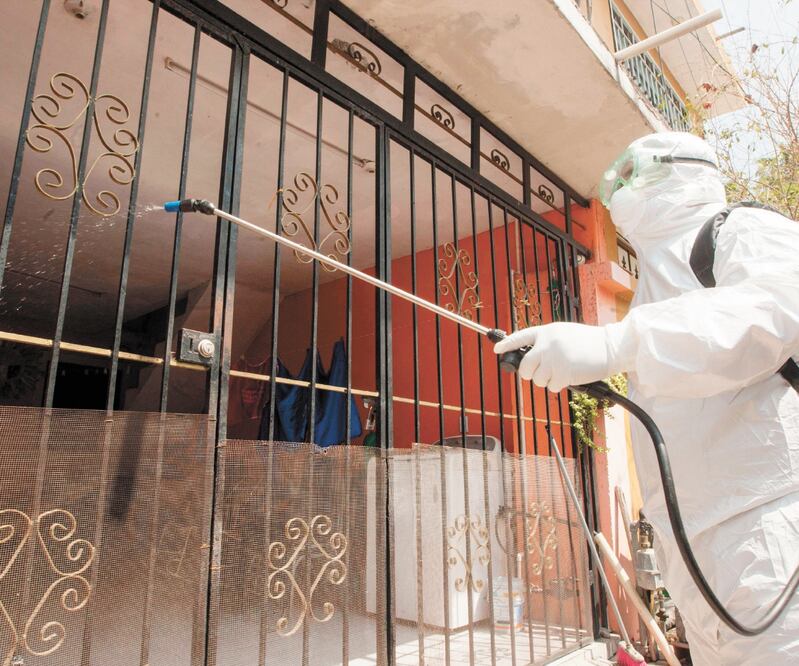 Un paramédico de Escobedo, Nuevo León, desinfecta una casa durante un simulacro de Covid-19. El protocolo aplicado en un posible caso contempla que la persona no abandone su dirección, que personal de salud desinfecte el área externa y proporcione un kit 