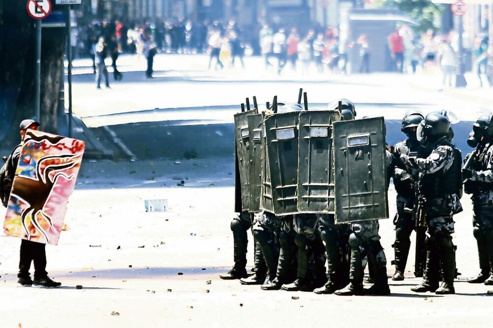 Manifestantes que se oponen a un paquete de austeridad propuesto por el gobierno, se enfrentaron ayer a fuerzas de seguridad, en Río de Janeiro (FABIO MOTTA. XINHUA)