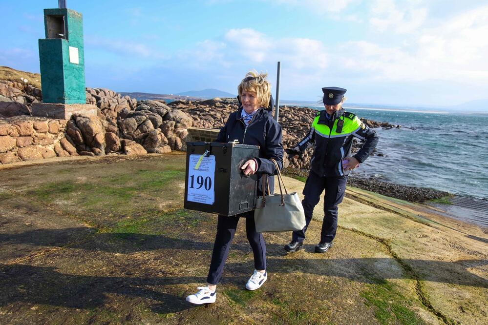 Garda Felicia Coll con la presidenta Nancy Sharkey, llega con las urnas a la isla Gola, frente a la costa de Donegal, en el oeste de Irlanda, mientras la votación en el referéndum constitucional irlandés se lleva a cabo. Foto: AFP