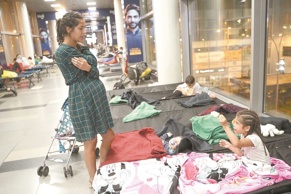 Paulina Meza, chilena de 30 años, con su hija en el Aeropuerto Internacional El Dorado, donde suspendieron vuelos, en Bogotá. REUTERS