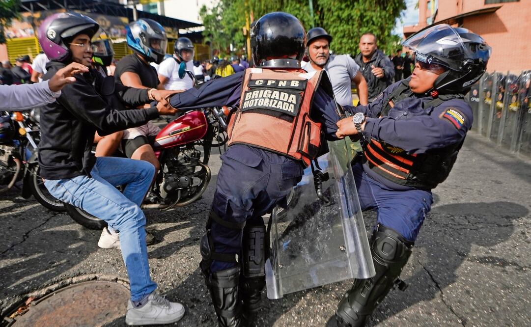 Un manifestante forcejea con la policía en las protestas contra los resultados de las elecciones, en Caracas. Foto: Especial