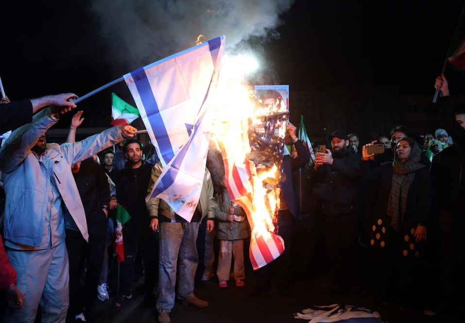 Iraníes queman las banderas de Estados Unidos e Israel, al celebrar en Teherán el cese el fuego declarado este martes. FOTO: AFP