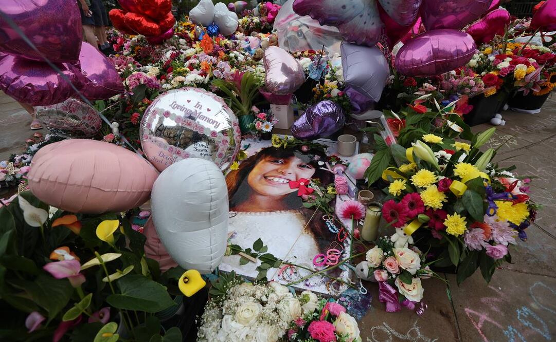 Fotografías de las víctimas del ataque con cuchillo de Southport se exhiben entre homenajes florales durante una vigilia para las víctimas. Foto: EFE