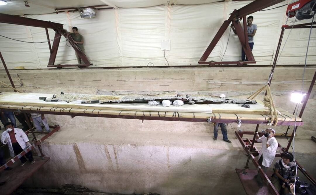 Excavadores y restauradores trabajan en la restauración de una viga de madera que al parecer conformó los remos de la segunda barca solar del faraón Keops. FOTO: Khaled Elfiqi/EFE.