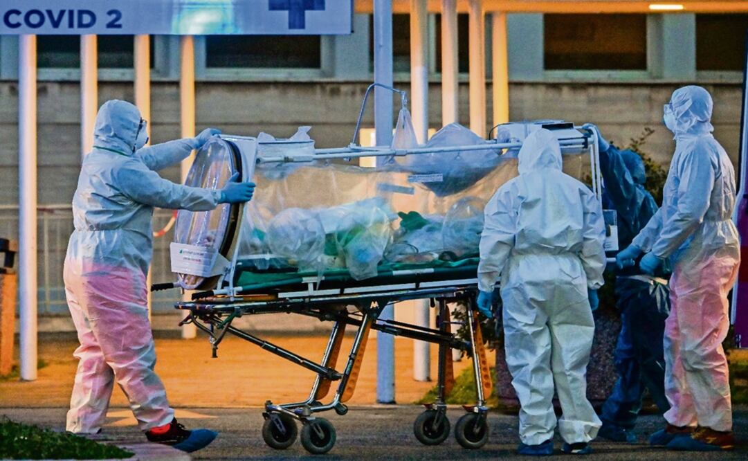 Medical workers in overalls stretch a patient under intensive care – Photo: Andreas Solaro/AFP