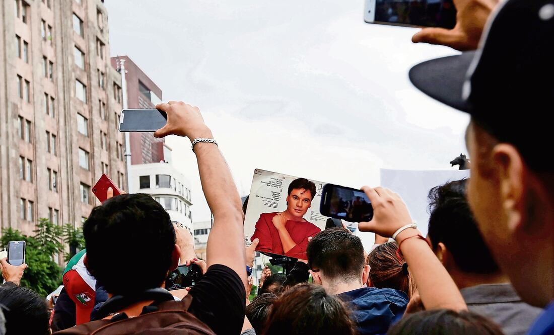 Aunque fuera de lejos, todos alzaban sus teléfonos celulares para captar la carroza donde iban los restos de Juan Gabriel (CARLOS JASSO. REUTERS)