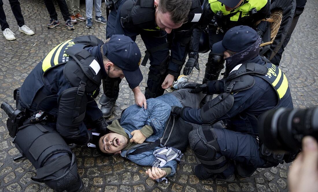 Un manifestante propalestino yace en el suelo rodeado por la policía holandesa en la plaza Dam de Ámsterdam, Países Bajos. FOTO: EFE