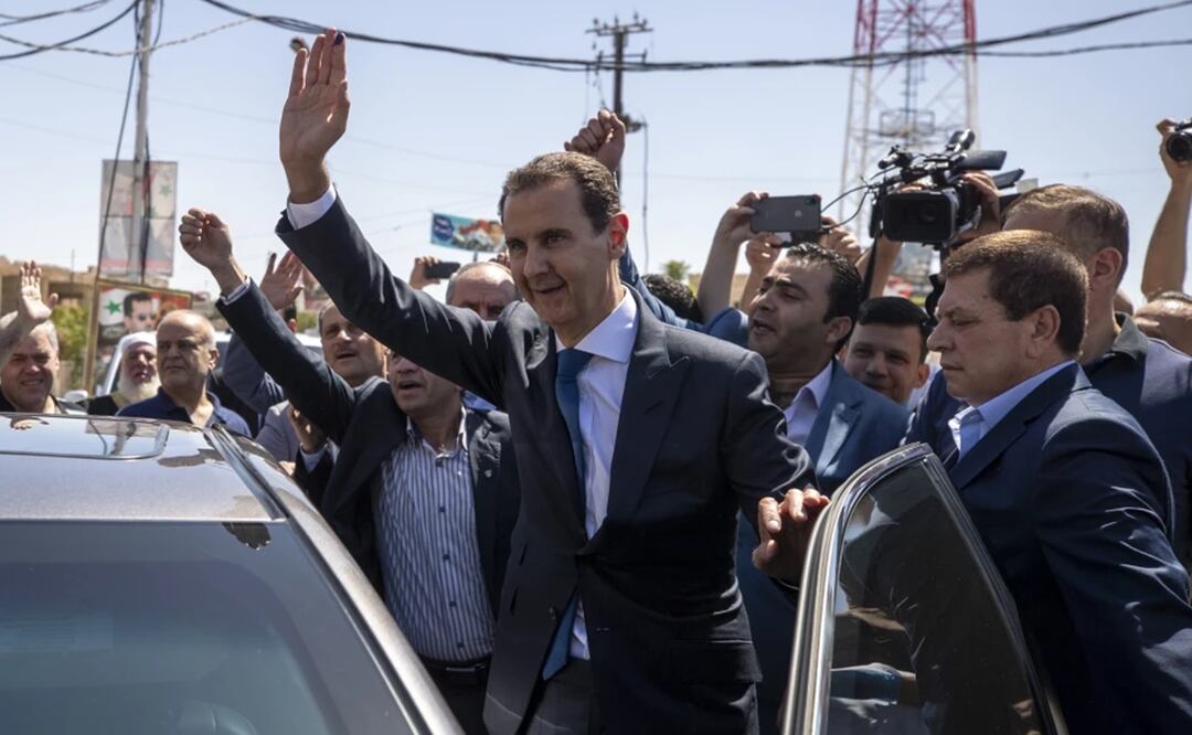 El presidente sirio Bashar Assad saluda a sus partidarios en una casilla electoral en Douma, cerca de Damasco, Siria, 26 de mayo de 2021. Foto. AP