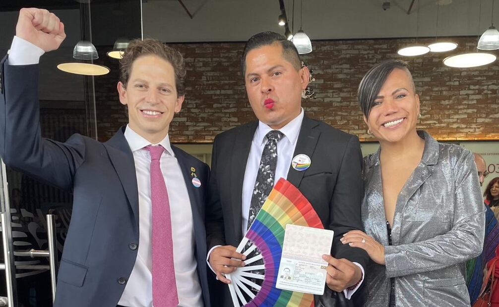 Jaime Vázquez Bracho, Director General de Servicios Consulares y diputada Salma Luevano acompañan al magistrade Jesús Ociel Baena a la entrega del primer pasaporte no binarie. Foto Twitter  @jaime_vbt