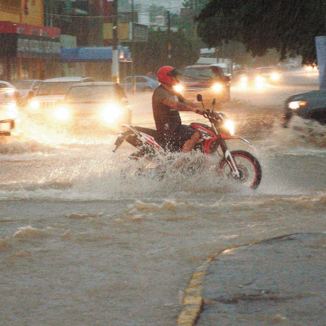 Un motociclista transita por una avenida inundada por las lluvias torrenciales provocadas por Lorena en la ciudad de Culiacán. Foto/JUAN CARLOS CRUZ. EFE