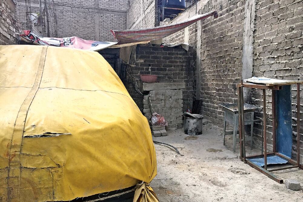 Desde una rendija en el zaguán, se observa que el domicilio de Itzel Nayeli luce vacío. En el patio permanece un auto cubierto con una lona (EMILIO FERNÁNDEZ. EL UNIVERSAL)