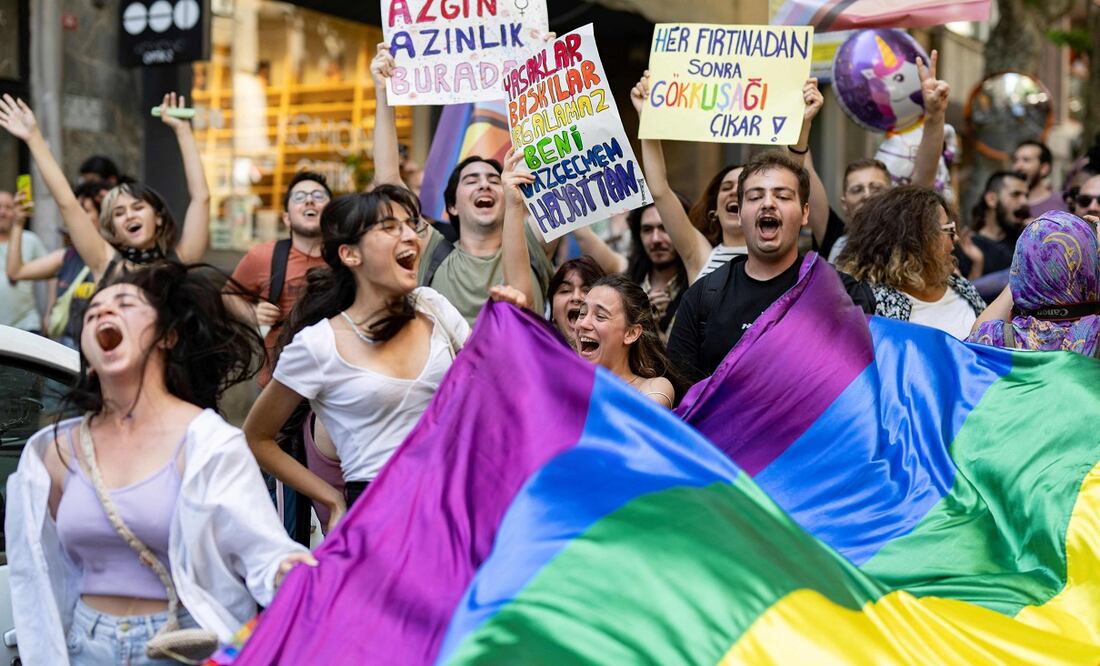 TOPSHOT - LGBTQ community members and supporters hold rainbow-colored flags and shout slogans during the unauthorized Pride March in Istanbul, on June 25, 2023. (Photo by YASIN AKGUL / AFP)