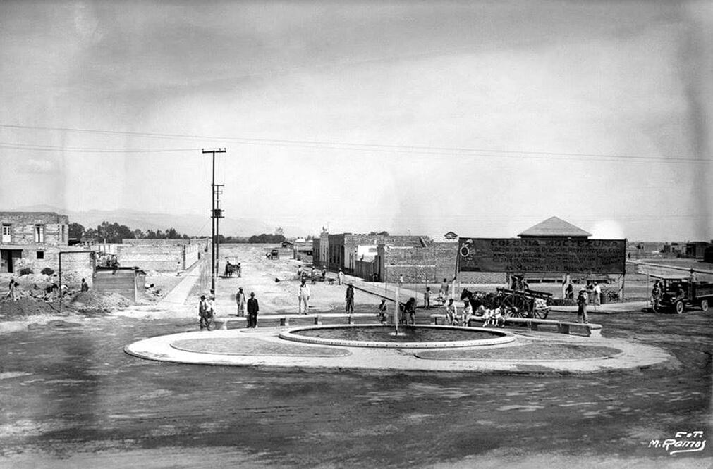 Una fotografía de los años treinta donde se aprecian las calles de la colonia Moctezuma. Esta fuente se encontraba en el cruce de la Carretera México-Puebla, hoy Calzada Ignacio Zaragoza, y las calles de Emilio Carranza y Francisco Espejel; la vista es hacia esta última. Imagen cortesía: Archivo fotográfico Manuel Ramos