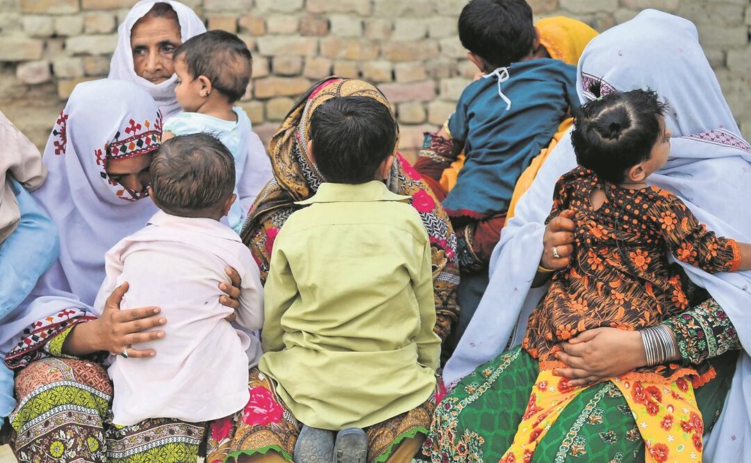 Mujeres paquistaníes sostienen a sus hijos infectados con el VIH mientras se reúnen en una casa en la aldea de Wasayo, en el distrito de Larkana, en 2019. Foto: Archivo / AFP