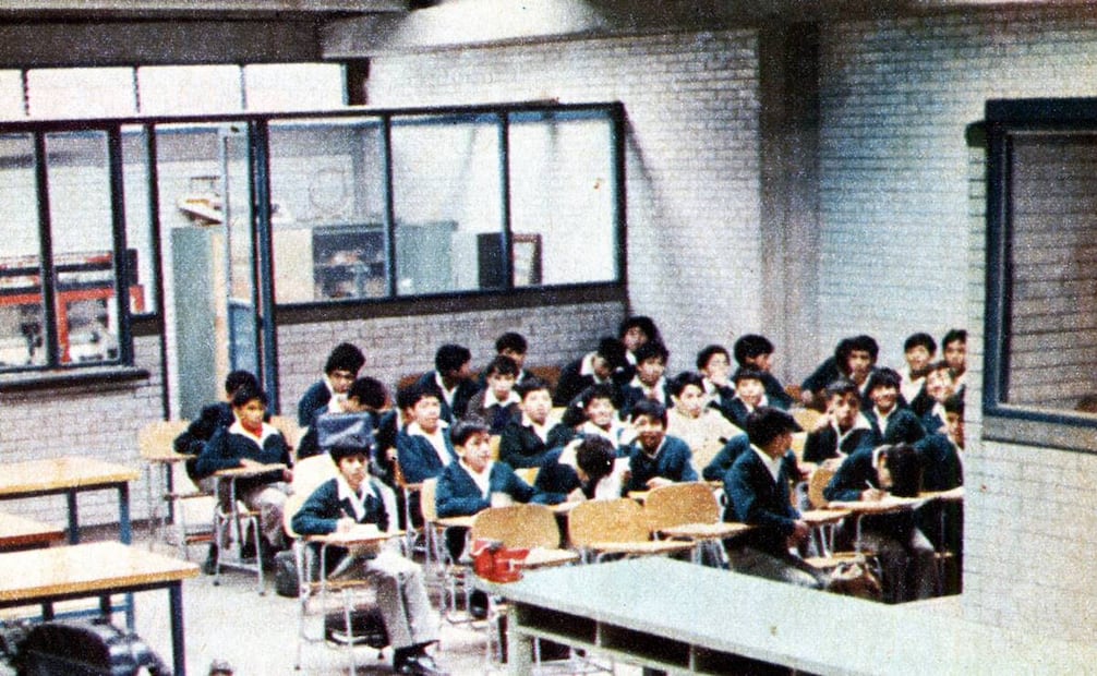 Salón de clases en los años ochenta en la que se aprecia a los estudiantes portando el típico uniforme de secundaria con el tradicional suéter verde y la playera blanca. Col. Carlos Villasana.