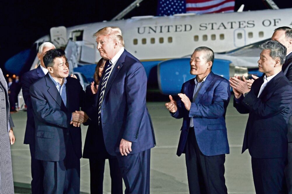 Trump (segundo de izq. a der.) al recibir ayer, en la Base de la Fuerza Aérea Andrews, en Maryland, a los estadounidenses que liberó Corea del Norte. (SUSAN WALSH. AP)