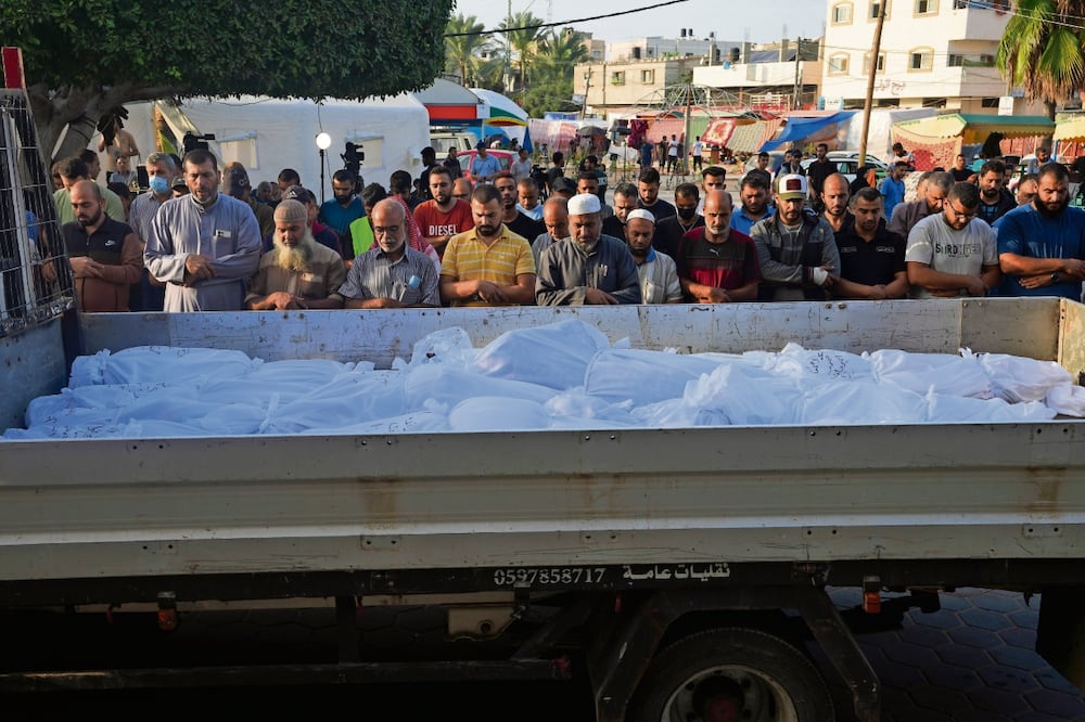 Palestinos rezan junto a los cuerpos de las personas muertas en el bombardeo israelí a Deir Al-Balah, en la Franja de Gaza. Foto: Adel Hana | AP