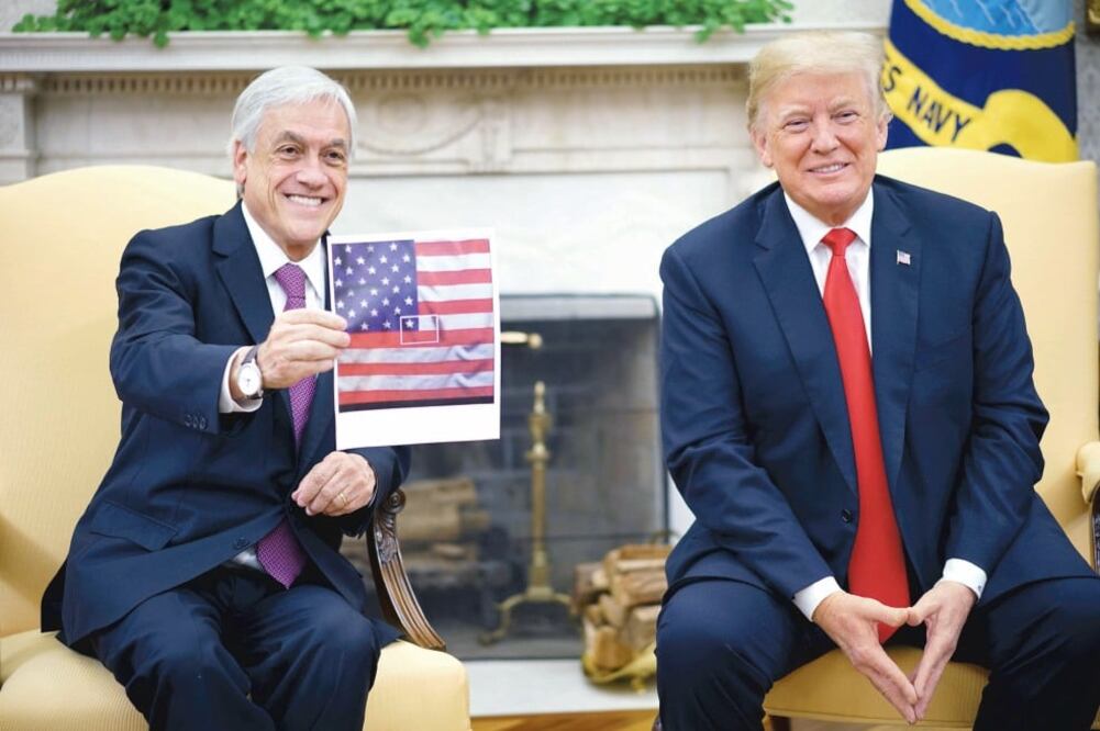 El presidente chileno Sebastián Piñera sostiene una imagen de la bandera de EU, con un fragmento enmarcado, como simulando la de Chile. Foto: MANDEL NGAN. AFP