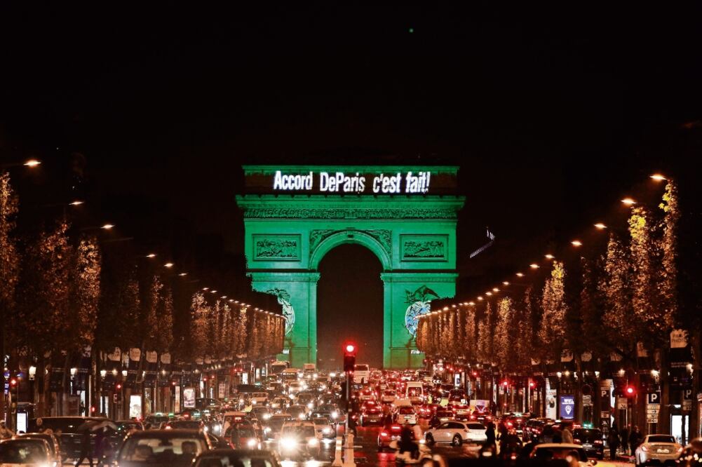 El Arco del Triunfo y otros monumentos de Francia se iluminaron de verde con motivo de la celebración del inicio del Acuerdo de París (YOAN VALAT. EFE)