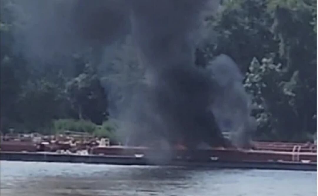 Foto suministrada por Adam Briggs que muestra a humo saliendo de una barcaza sobre la cual cayó un helicóptero en el río Mississippi cerca de Alton, Illinois, el 7 de agosto del 2025. Foto: AP