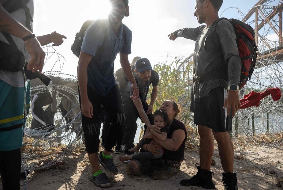 Maria Argentina, hondureña de 32 años, con su hija Natalie Virginia, después de ser auxiliadas para cruzar el Río Grande (Bravo) y llegar a Eagle Pass. Argentina no tiene piernas y no pudo cruzar con su silla de ruedas. FOTO: ANDREW CABALLERO-REYNOLDS. AFP