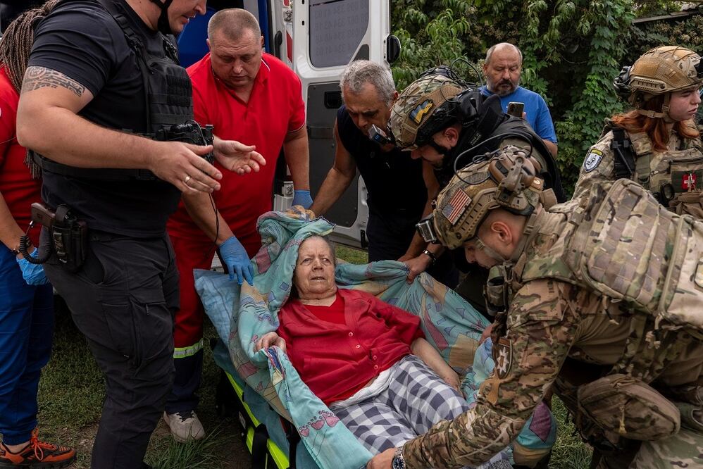 Policías y médicos ayudan a trasladar a Olha Trush, de 86 años, afectada por el ataque ruso en la localidad de Yarova. FOTO: ALEX BABENKO. AP