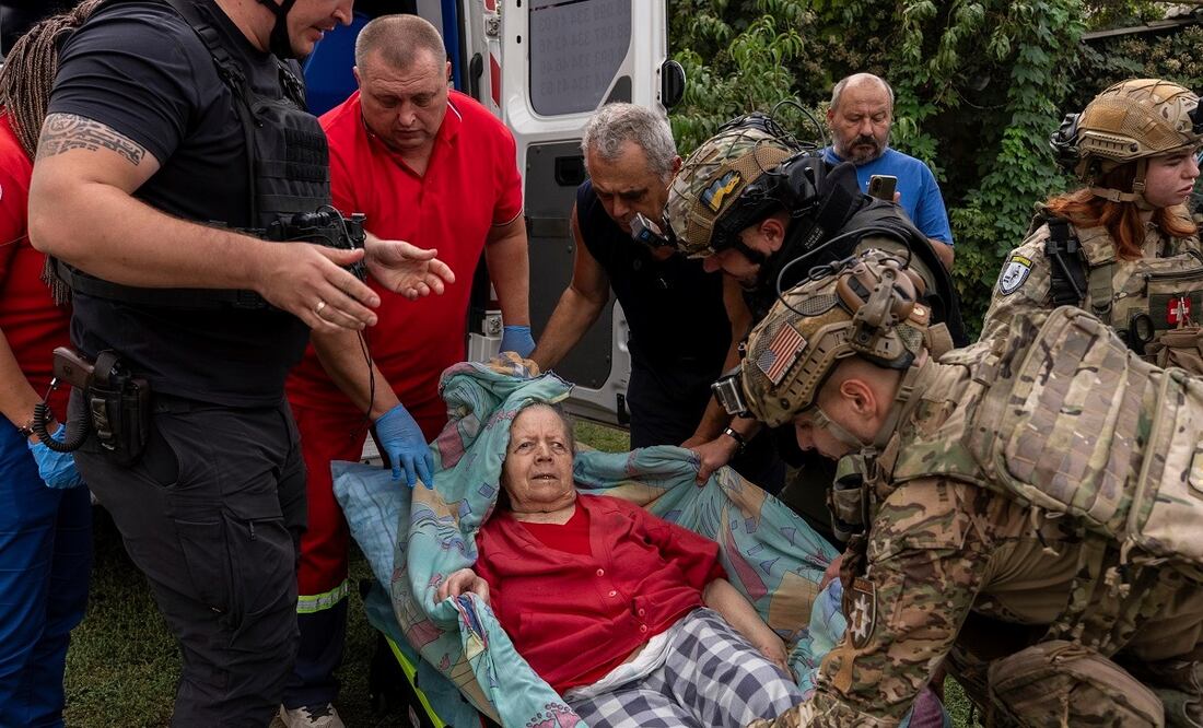 Policías y médicos ayudan a trasladar a Olha Trush, de 86 años, afectada por el ataque ruso en la localidad de Yarova. FOTO: ALEX BABENKO. AP