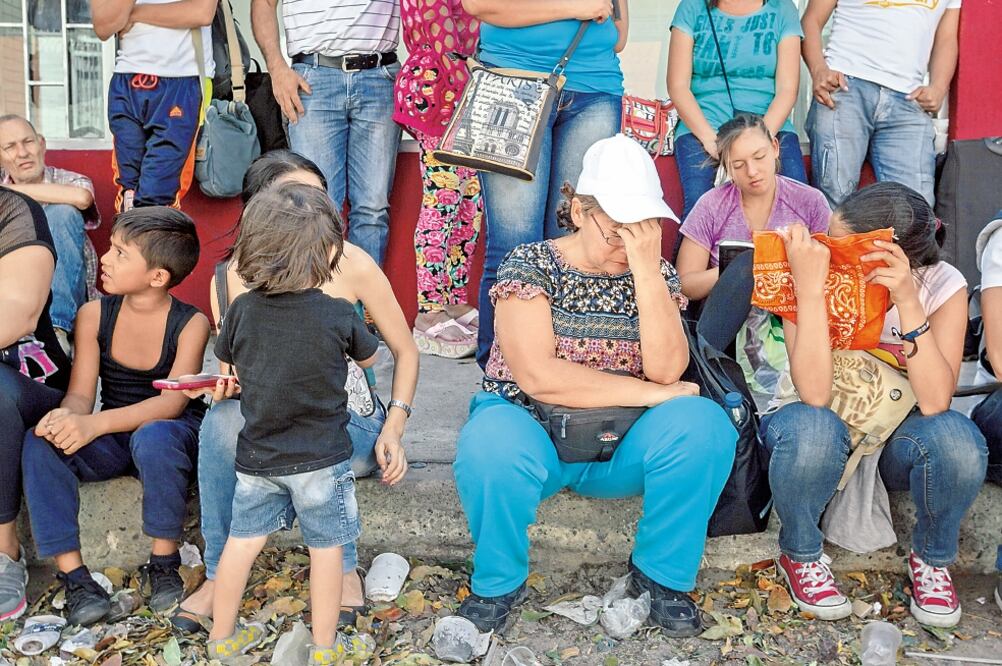 Un grupo de personas aguarda en las inmediaciones de la Aduana Principal fronteriza entre Colombia y Venezuela para poder cruzar el puente internacional (MIGUEL GUTIÉRREZ. EFE)