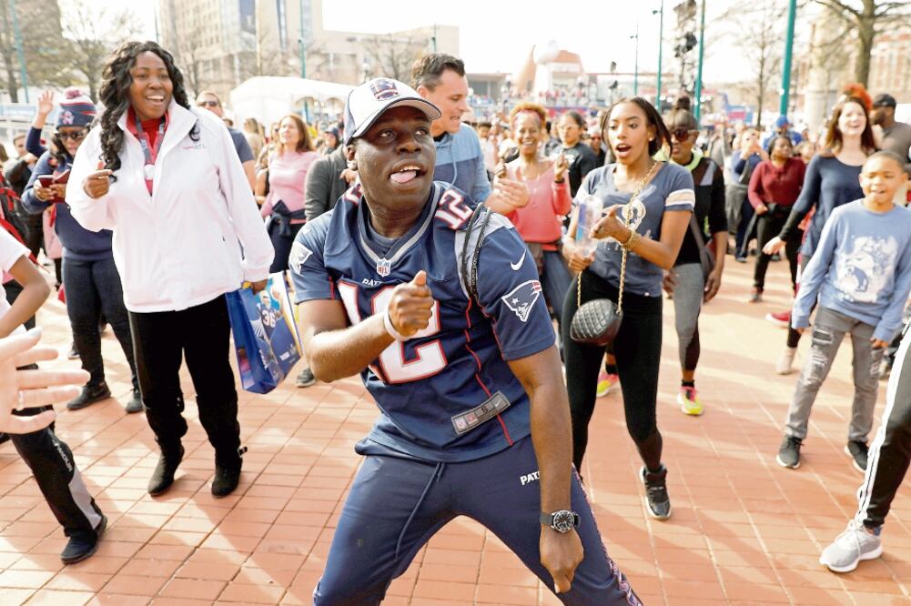 Fanáticos del futbol americano bailan y festejan afuera del estadio, durante las festividades del Super Bowl en Atlanta, Georgia. (KEVIN LAMARQUE . REUTERS)