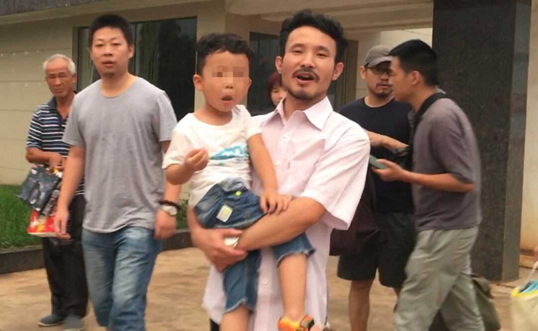 Uno de los activistas, Hua Haifeng, cargaba a su hijito de 3 años cuando salía de la sede policial con su esposa y otros familiares (Foto: AP)
