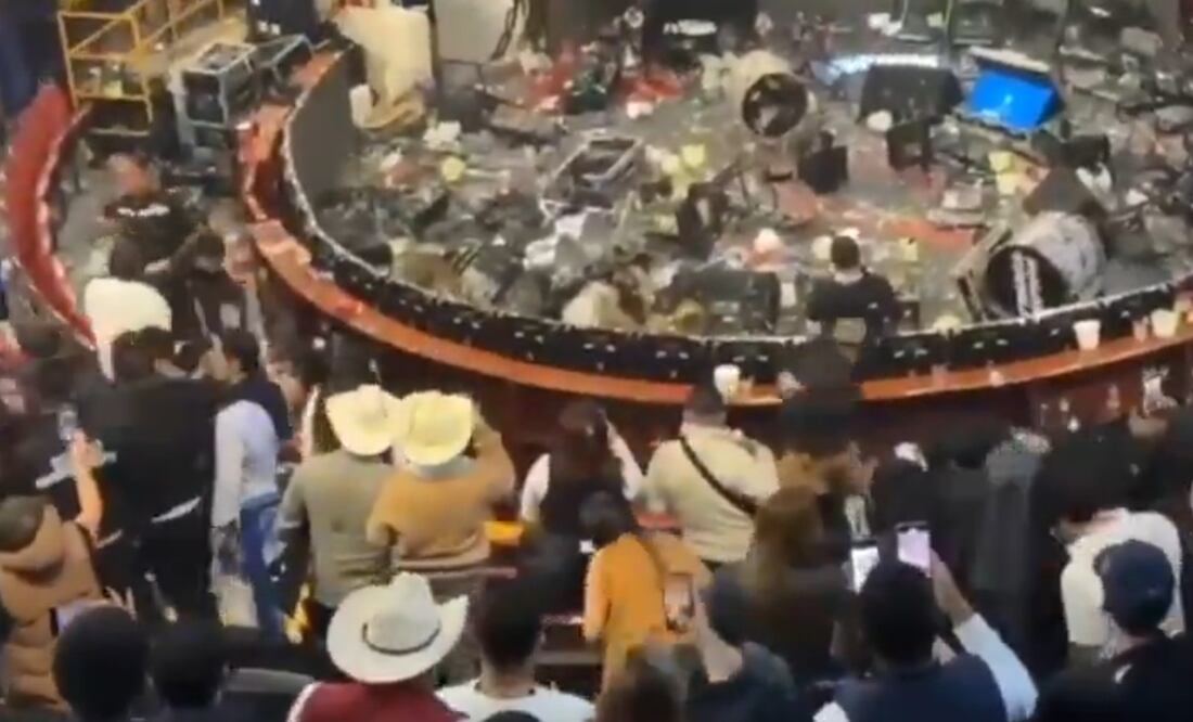Algunos de los asistentes tomaron las sillas del lugar para aventarlas hacia la zona del escenario. Foto: Captura de pantalla